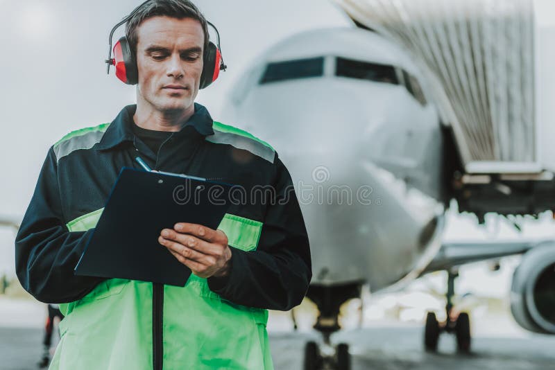 Mecanic serios în căști cu căști roșii care au loc de muncă royalty free stock photos
