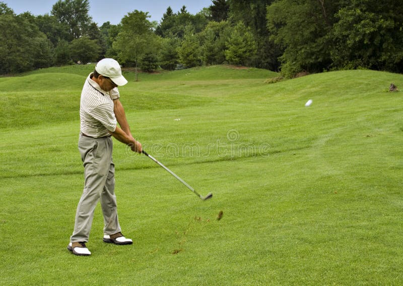 Action golf shot from fairway - Ball and turf flying through the air. Action golf shot from fairway - Ball and turf flying through the air.