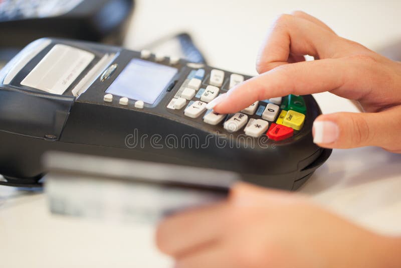 Hands of a women typing in her pin code into the card reader. Hands of a women typing in her pin code into the card reader.