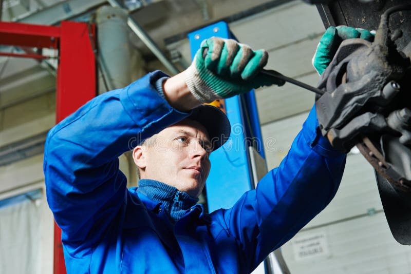 Meccanico alla riparazione della sospensione dell'automobile fotografia stock libera da diritti Meccanico alla riparazione della sospensione dell'automobile fotografia stock libera da diritti