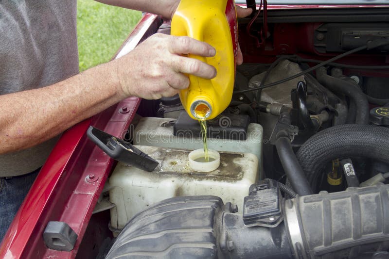 A Mechanic Adding Coolant To A Older Truck