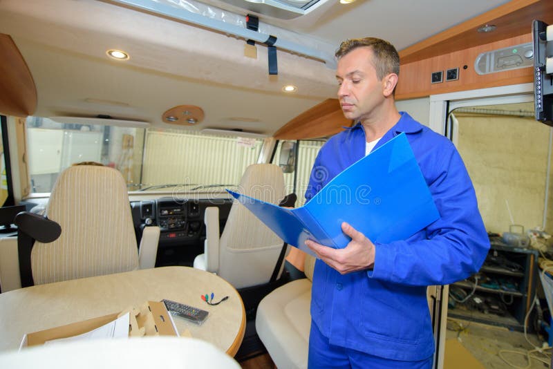 Mechanic in Camper Van Looking in Folder Stock Photo Image of home, worker 123024548