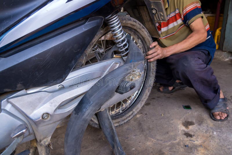 Mechanic Changing Motorcycle Tire in Garage Stock Photo - Image of