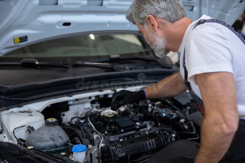 Mechanic checking oil level in engine royalty free stock image