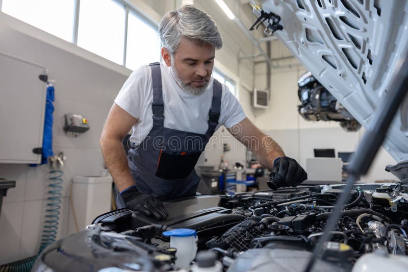 Mechanic checking oil level in engine royalty free stock images