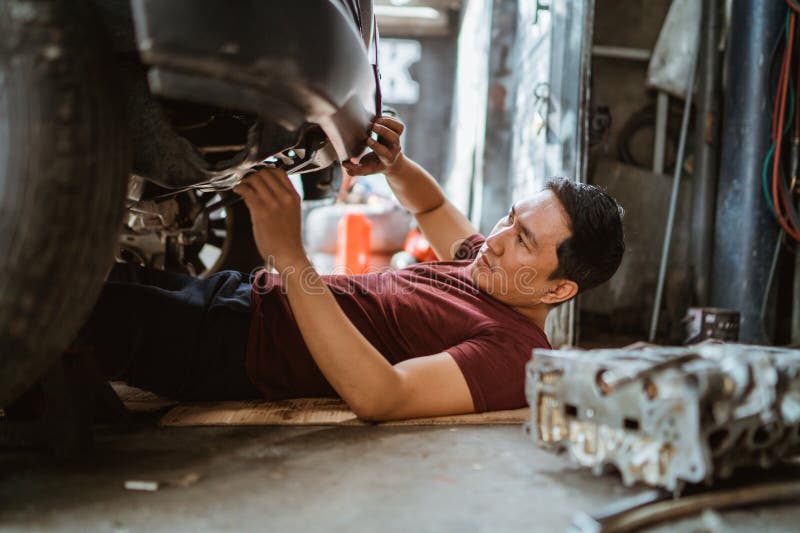 Mechanic checks the damage on the lower front of the car stock images