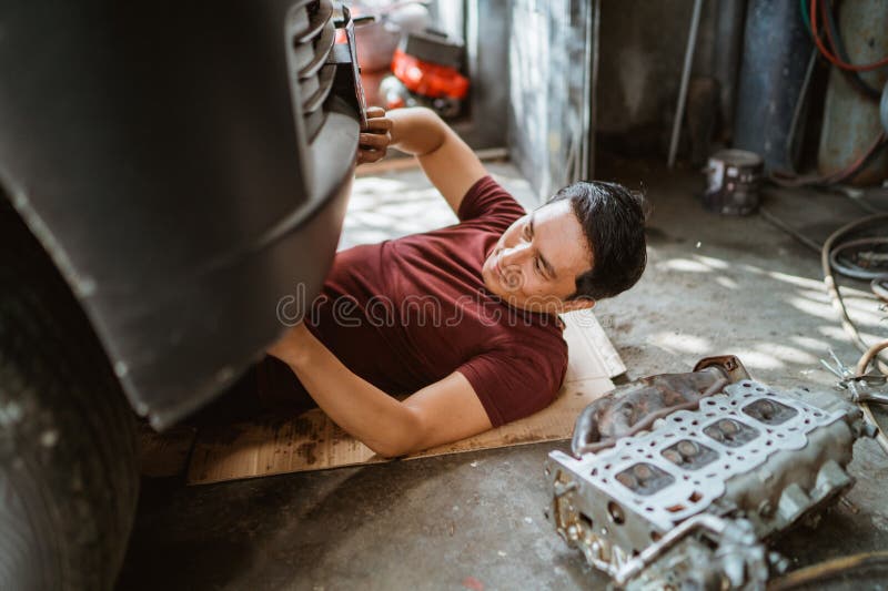 Mechanic checks the damage on the lower front of the car royalty free stock photography
