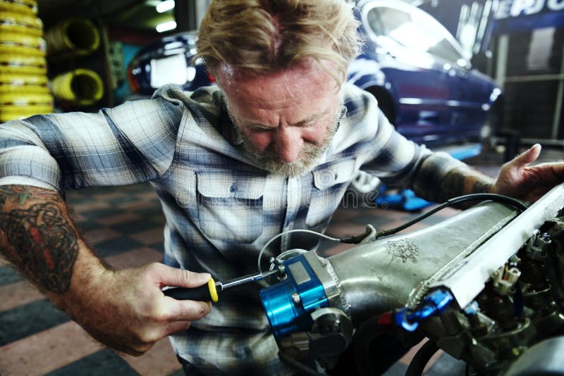 A mechanic fixing an engine stock image