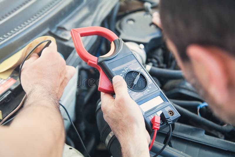 Mechanic with a Multimeter Testing Car Engine. Car Service Stock Photo