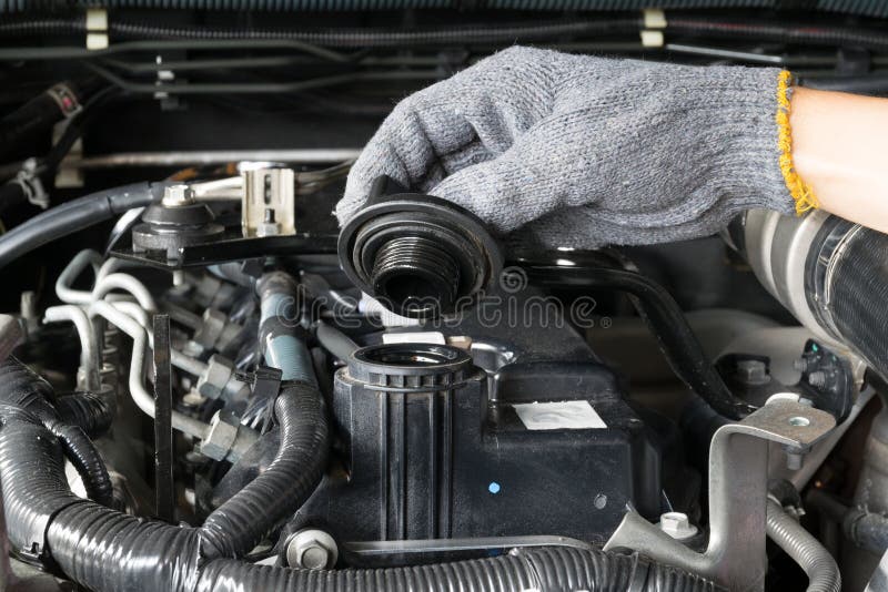 A mechanic is opening the oil cap from a car engine. stock photos