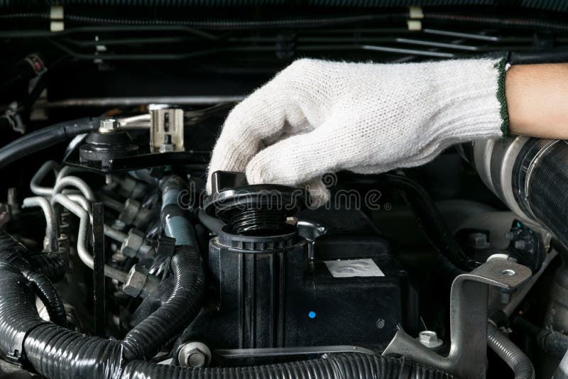 A mechanic is opening the oil cap from a car engine. royalty free stock photos