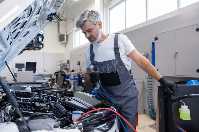 Mechanic with toolbox and laptop in workshop stock photo