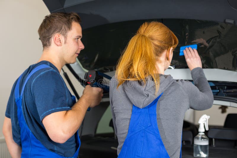 Mechanic tinting car window with tinted foil or film stock image Mechanic tinting car window with tinted foil or film stock image