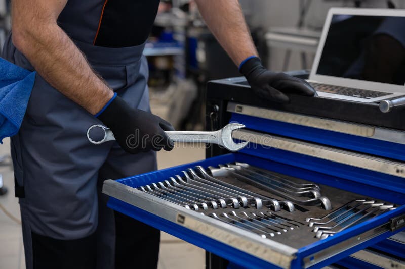 Mechanic with toolbox and laptop in workshop stock images