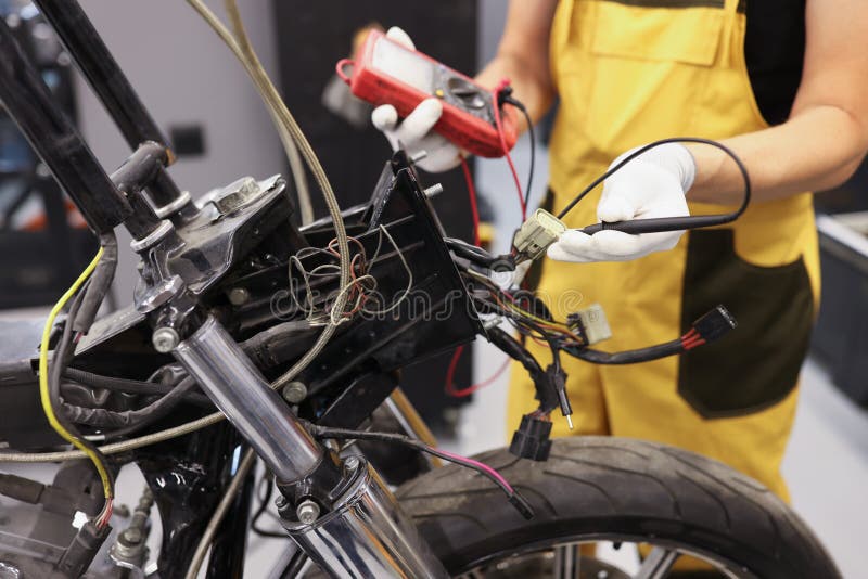 Mechanic Using Multimeter Checks Voltage Level Motorcycle Battery