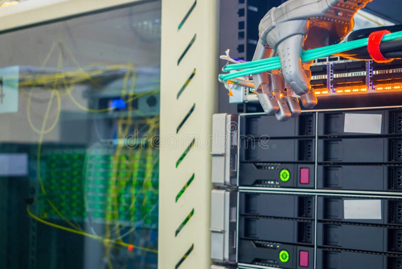 The mechanical arm of the robot connects the wires in the server room. A robotic manipulator in the form of a hand works in the stock photo