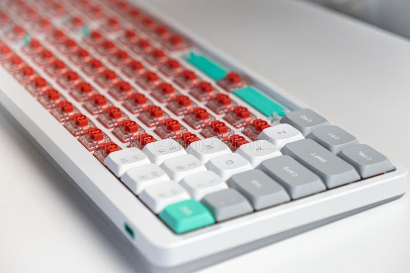 Mechanical keyboard with custom red switches and keycaps in the process of full assembly setup. Close-up of a mechanical keyboard featuring exposed red switches and colorful keycaps during a custom build, highlighting hobbyist design, tactile feedback, and ergonomic tech enhancement