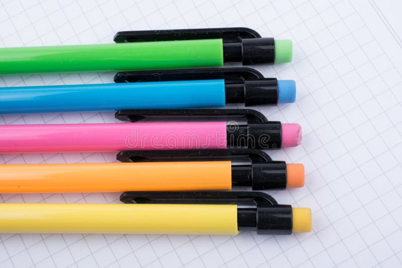Mechanical pencils of various color on a notebook