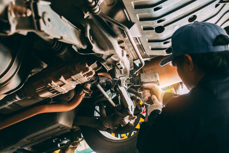 Mechanician changing car wheel in auto repair shop