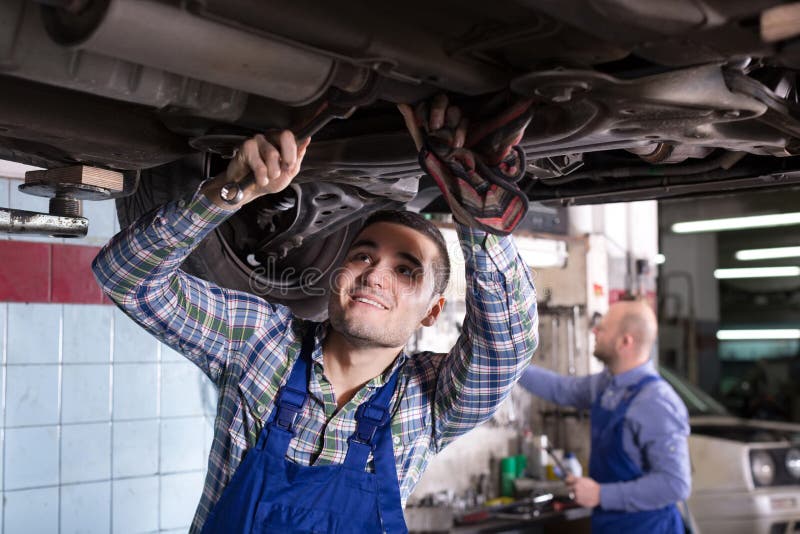 Mechanic fixes. Мужчина чинит Мерседес Спринтер в гараже. Fixing a car.