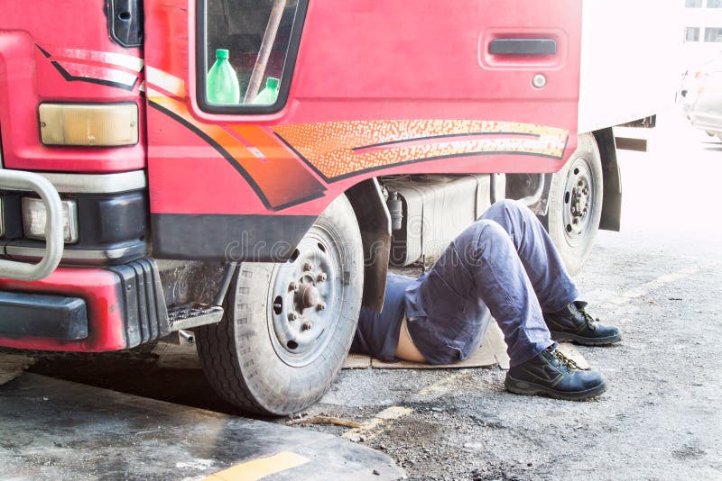 Mechanik pod ciężarowego naprawiania brudnym otłuszczonym wazeliniarskim silnikiem z prob