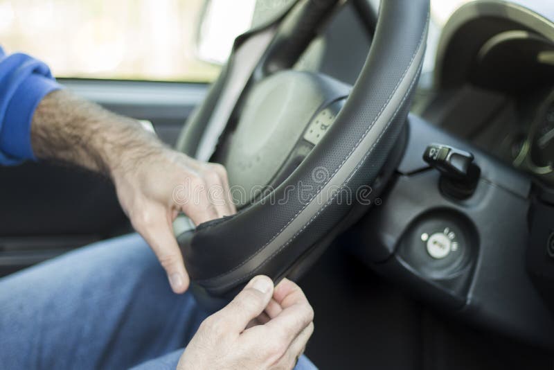 The mechanic puts weel cover on the steering wheel of the car. The mechanic puts weel cover on the steering wheel of the car.