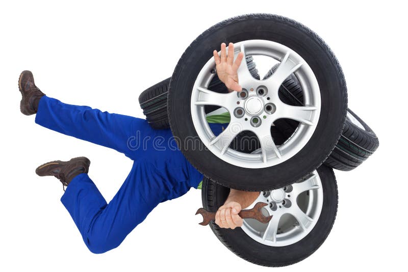 Mechanik zakrywający samochodowymi oponami fotografia stock Mechanik zakrywający samochodowymi oponami fotografia stock