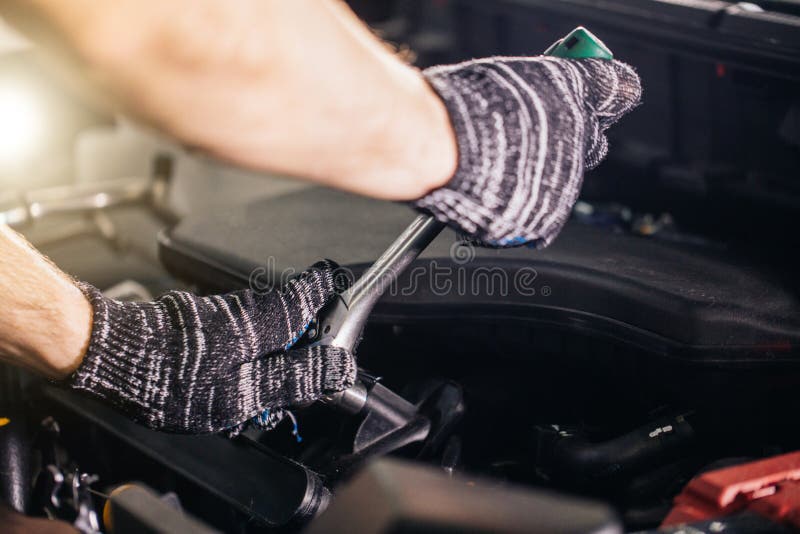 Mechaniker seine Reparaturwerkstatt, die nahes Auto steht Nahaufnahmemaschine stockbild Mechaniker seine Reparaturwerkstatt, die nahes Auto steht Nahaufnahmemaschine stockbild
