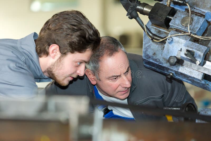 Mecánico de aprendiz en taller de automóviles que trabaja en el motor de automóviles. Aprendiz mecánico en taller de autos trabajando en aprendiz de motor de auto