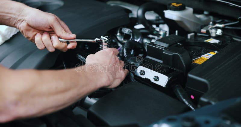 Mecánico de automóviles trabajando con llave en el motor del vehículo en el servicio de automóviles. mantenimiento y reparación metrajes
