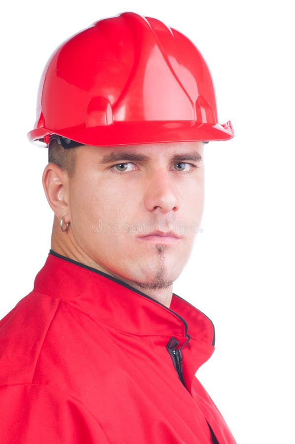 Mecánico hermoso joven con el casco y las herramientas y en guardapolvos imagen de archivo