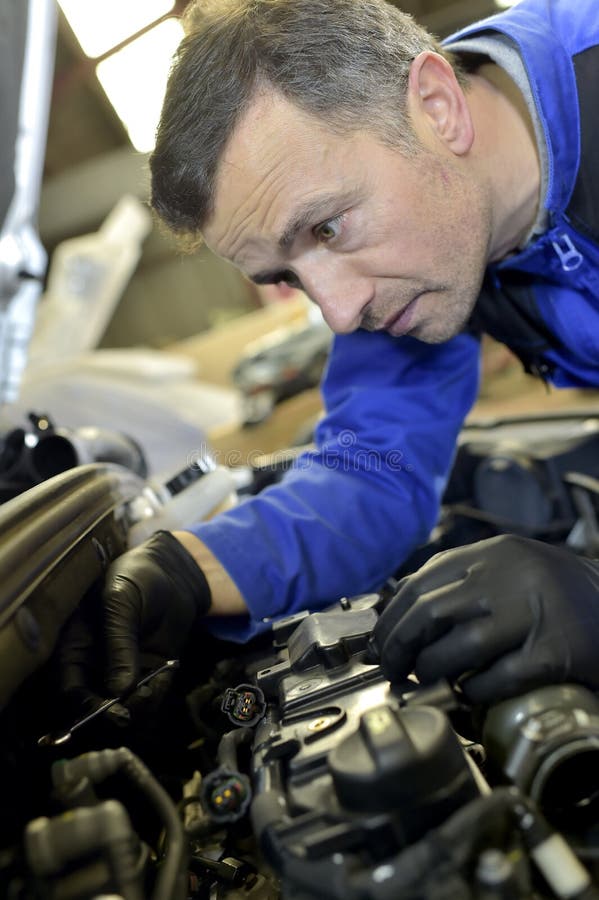 Mecánico que trabaja en reparaciones del coche fotografía de archivo libre de regalías Mecánico que trabaja en reparaciones del coche fotografía de archivo libre de regalías