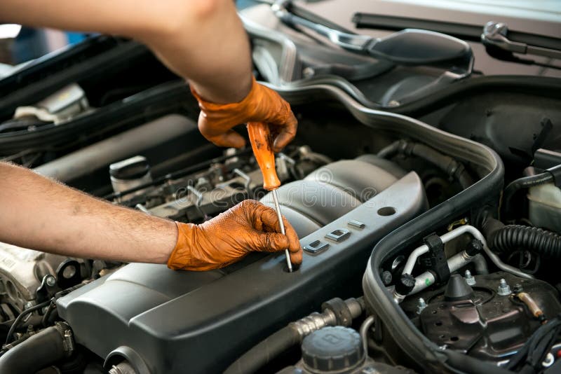 Mecánico que trabaja en un motor de coche foto de archivo libre de regalías Mecánico que trabaja en un motor de coche foto de archivo libre de regalías