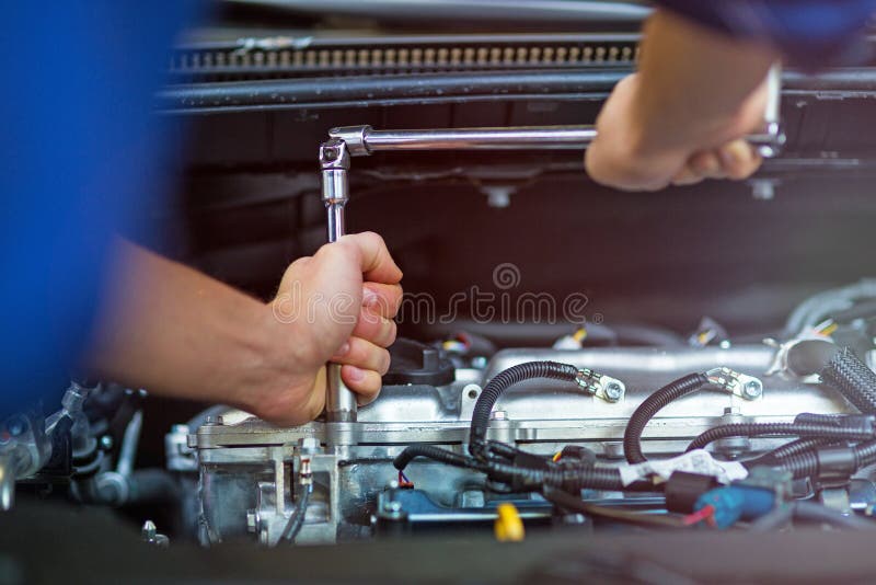 Mecânico que trabalha no motor de automóveis na loja de reparação de automóveis fotos de stock royalty free Mecânico que trabalha no motor de automóveis na loja de reparação de automóveis fotos de stock royalty free