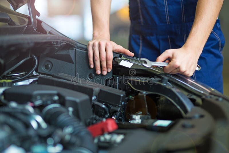 Hands of mechanic working on car engine in auto repair shop. Hands of mechanic working on car engine in auto repair shop