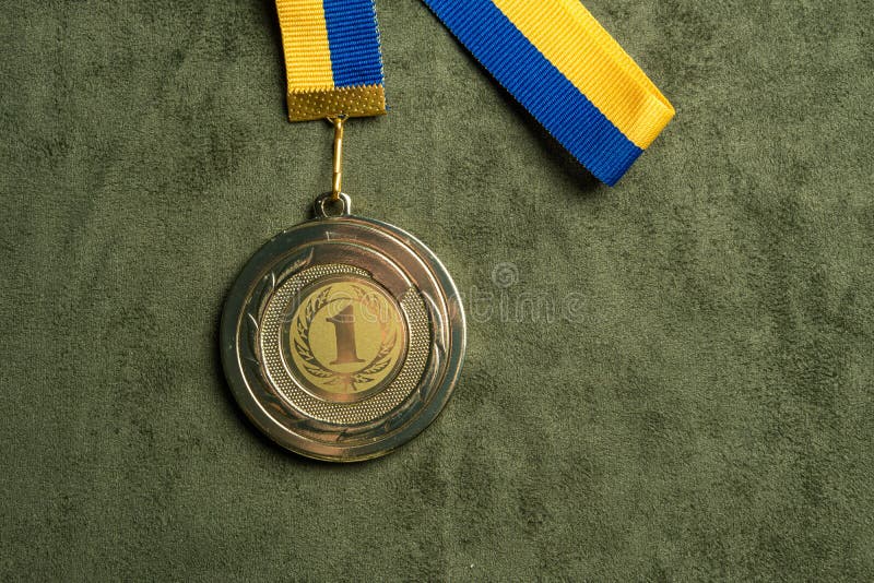 Medalla de oro para el primer lugar con la cinta amarilla y azul imagenes de archivo Medalla de oro para el primer lugar con la cinta amarilla y azul imagenes de archivo