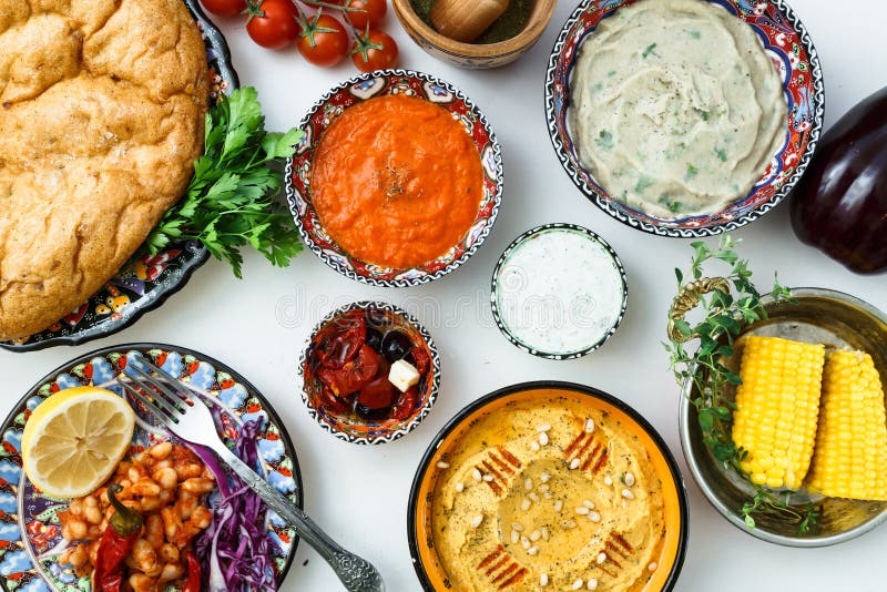 Medelhavs- traditionell meze: hummus babaganoush, harissa, tzatziki på vit bakgrund royaltyfri bild Medelhavs- traditionell meze: hummus babaganoush, harissa, tzatziki på vit bakgrund royaltyfri bild