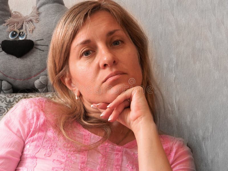 Medelålders kvinnlig porträtt. Lugn yta på 40 år flicka som sitter hemma på egen isolering under karantänlåsning royaltyfri foto