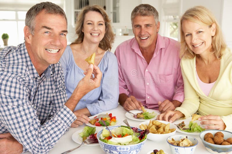 Mediados de pares de la edad que disfrutan de la comida en el país imagenes de archivo Mediados de pares de la edad que disfrutan de la comida en el país imagenes de archivo