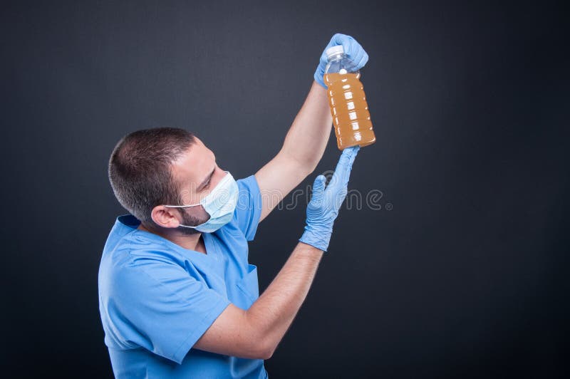 Medic wearing face mask looking at dirty water royalty free stock image