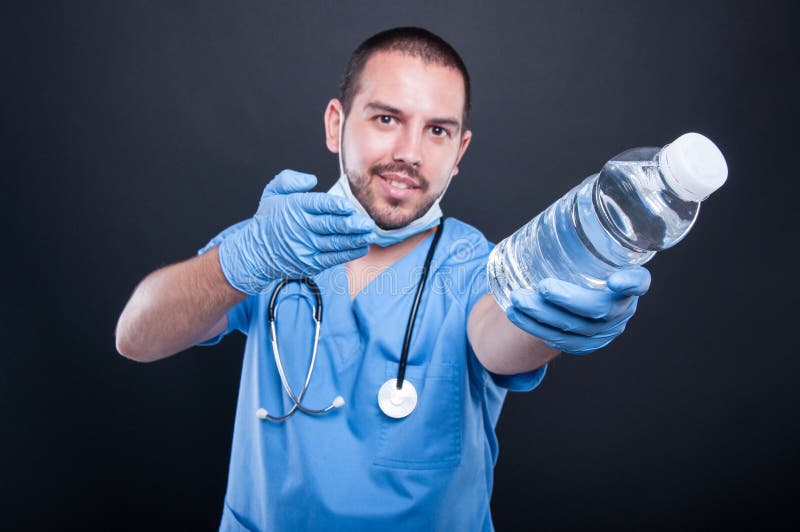 Medic wearing scrubs showing bottle of water royalty free stock photos