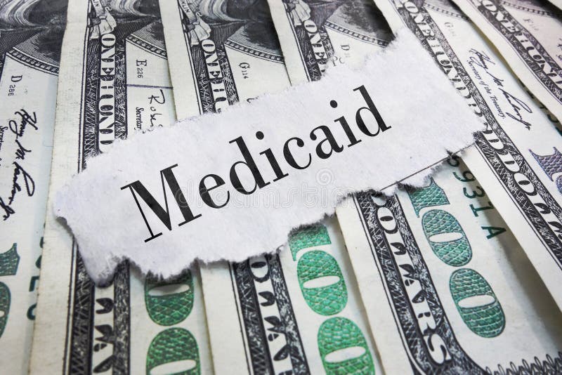 Medicaid headline. Medicaid torn newspaper headline on cash stock images