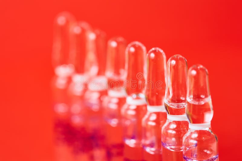 Medical ampules on a red background, selective focus.