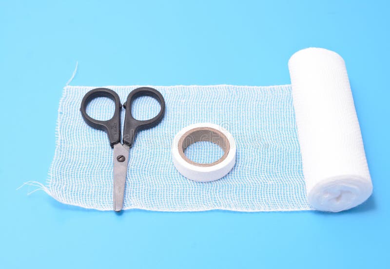 Medical Plaster, Cotton Wool, Scissors and Bandage Isolated on a Blue