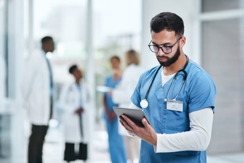 Medical, doctor and tablet with a man in a clinic reading healthcare and wellness data at hospital. Employee, nurse and