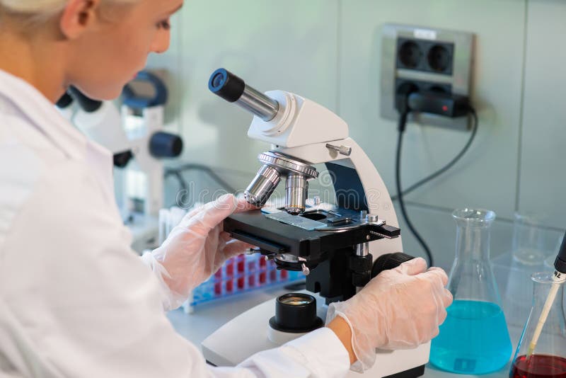 Medical doctor working in research lab. Science assistant making experiments. Laboratory tools: microscope, test tubes