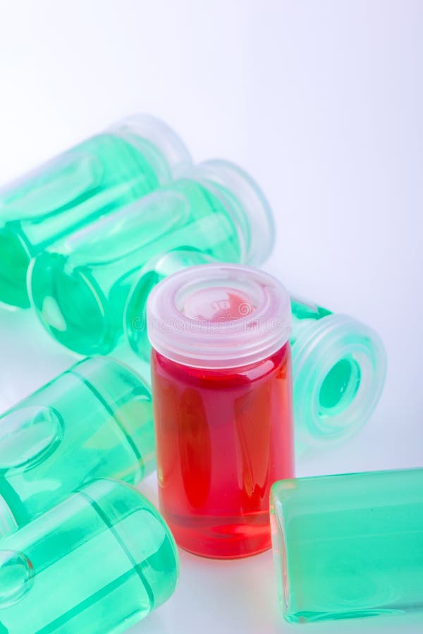 Liquid Serum Drop from Pipette into a Cosmetic Transparent Glass Bottle