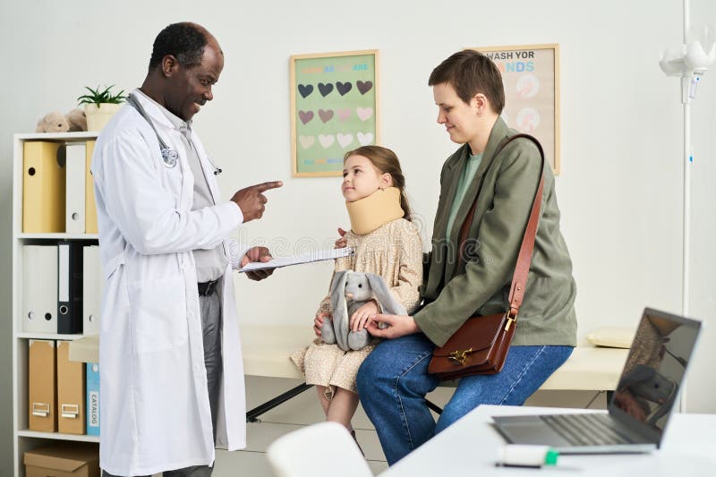 Medical Professional Assisting Patient and Guardian stock photo