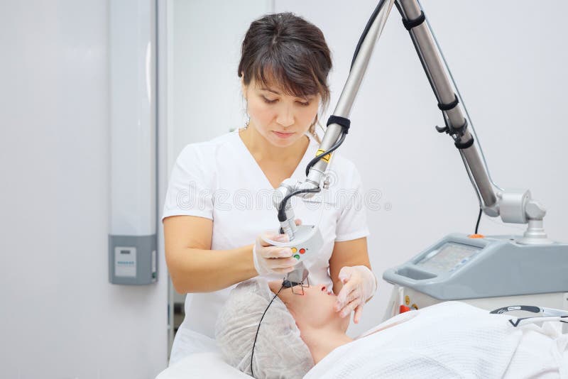 Medical salon employee uses neodymium laser removing scars