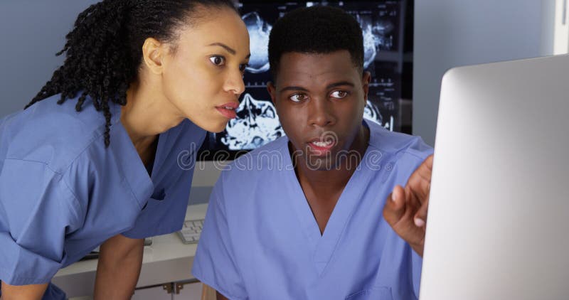 Medical specialist working with colleague on computer stock photo